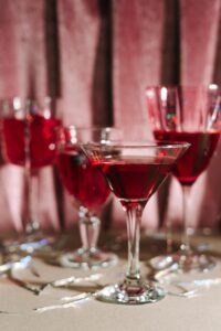 A selection of elegant red cocktails in crystal glassware set against a luxurious background.