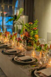 An inviting dinner table setup featuring elegant florals and glowing candlelight for an intimate gathering.