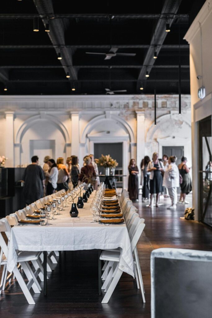 A long table exquisitely set for a formal dinner event in a luxurious indoor setting.